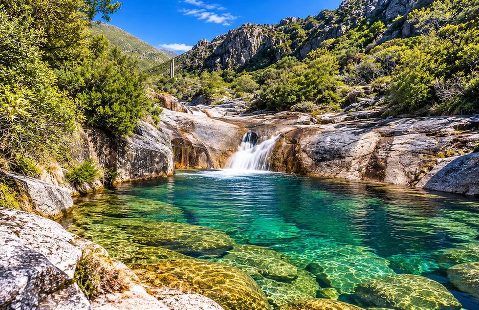 Lagoa de águas cristalinas e pequena cascata entre as rochas das Sete Lagoas no Gerês